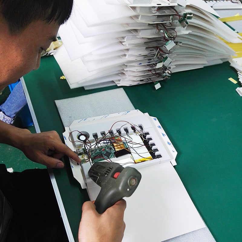 A man using an electronic device to check the packaging.