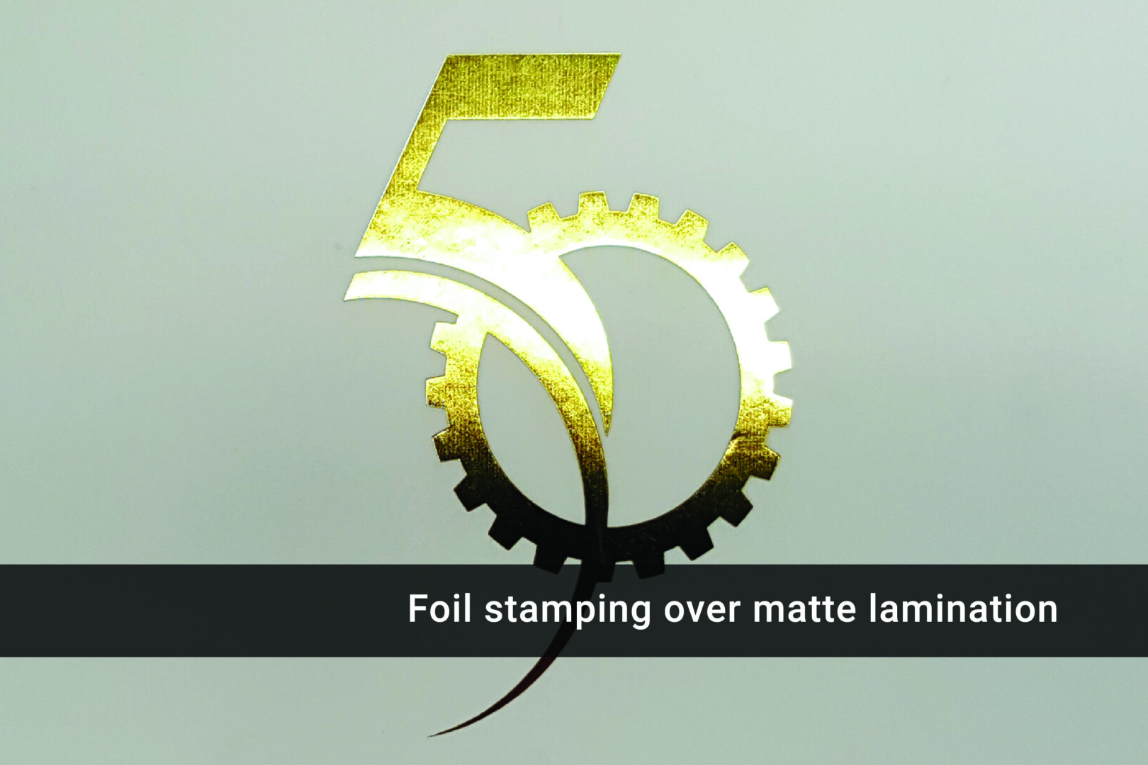 A foil stamping over matte laminate is in the shape of a number five.